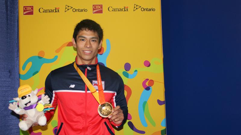 Jorge Carinao Cárdenas Jorge Carinao Cárdenas claims gold on the first day of powerlifting at the Toronto 2015 Parapan American Games on Saturday (8 August). He faces the camera holding the TO2015 mascot and his gold medal.