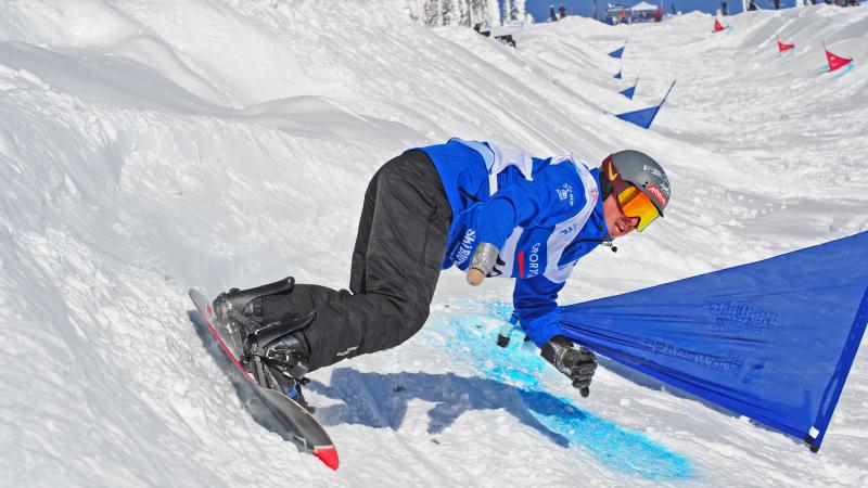 France's Maxime Montaggioni - snowboard Man on snowboard turns on a banked slope