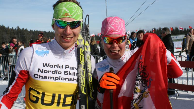 Carina and Julian Edlinger - Austria - Cross-country skiing Two cross-country skiers with an Austrian flag