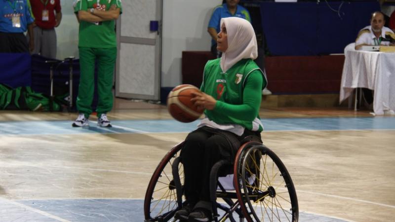 Algeria's Djamila Khemgani - wheelchair basketball Woman wearing a hijab shooting a basketball in a wheelchair