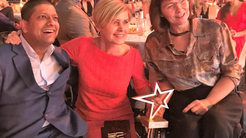Mansoor Siddiqi and Connie Hansen a man and two women smiling with a trophy
