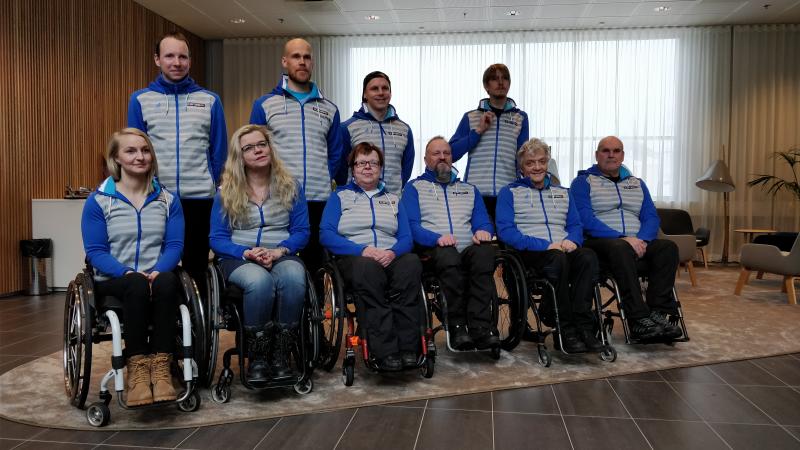 Team Finland for PyeongChang 2018 Paralympic Winter Games Four people standing behind a group of six people in wheelchairs