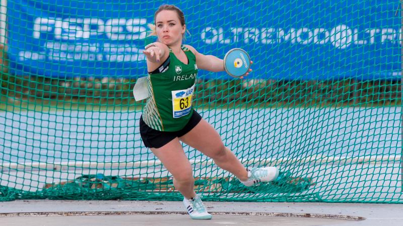 Short statured female discus thrower competing