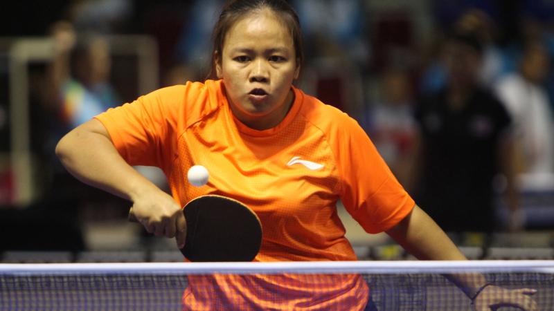 Indonesia Suwarti Suwarti - Para table tennis - Asian Para Games Woman in orange shirt playing table tennis