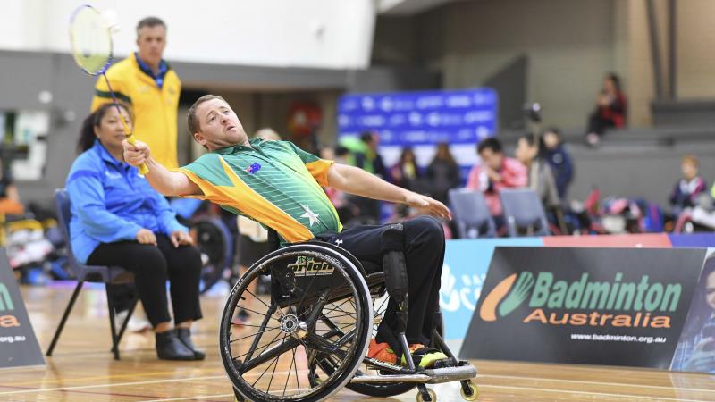 Australia - badminton Male Australian badminton player in a wheelchair attempts to hit the birdie in the air