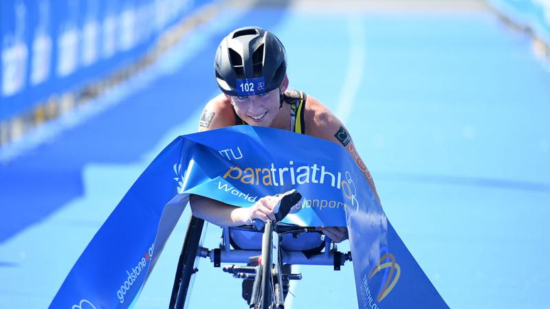 Lauren Parker - triathlon - Australia Australian woman in racing wheelchair crosses the finishline tape at a triathlon event
