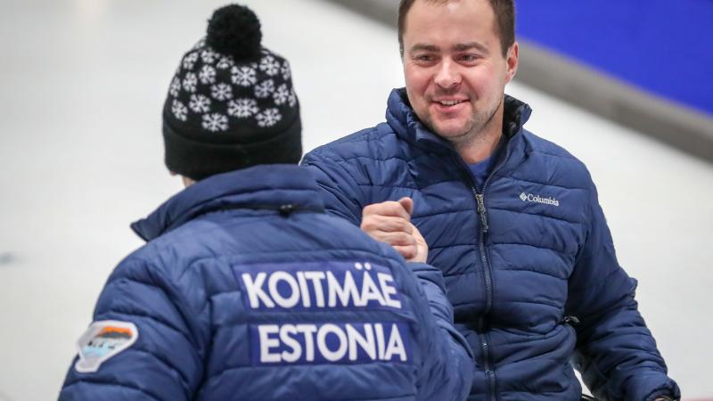 Viljar Villiste - Estonia - wheelchair curling Two male wheelchair curling teammates clasp hands