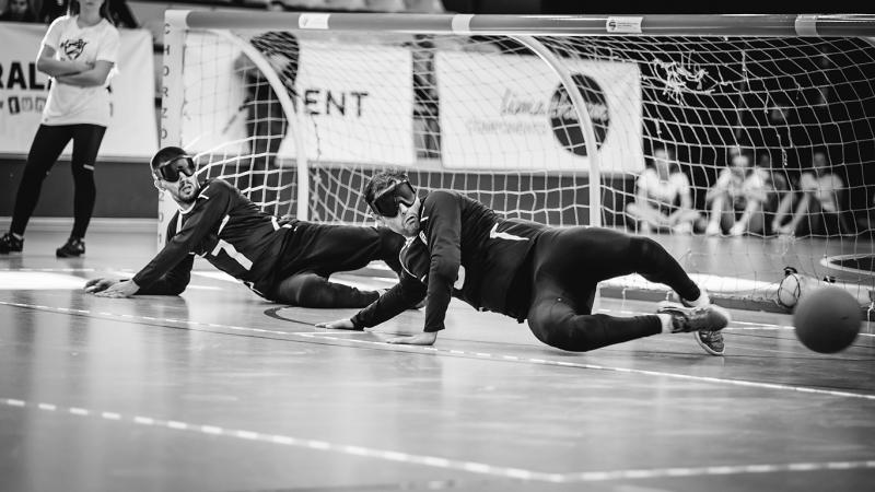Greece men's goalball a team of male goalball players standing with their arms linked on a court