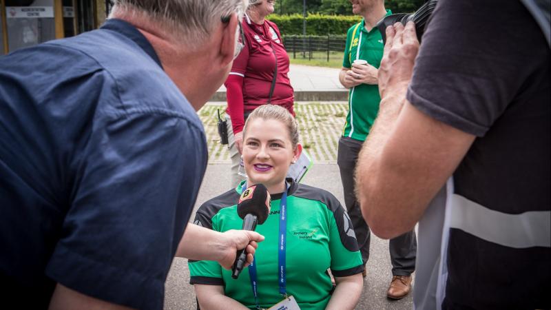 Woman in wheelchair being interviewed by media