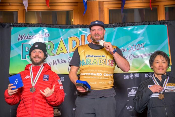 Three male athletes pose for a photo with their medals